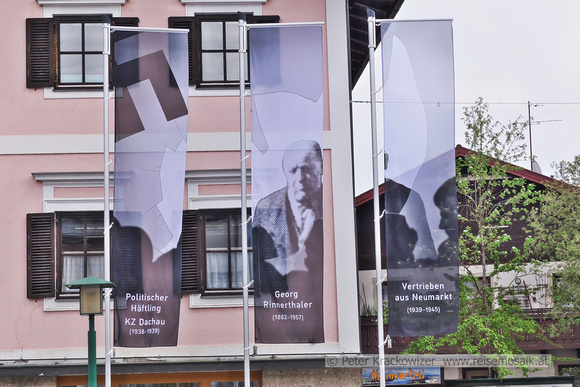 Fahnen vor dem Stadtamt in Neumarkt am Wallersee  machen auf das Kunstprojekt Einwurf aufmerksam.